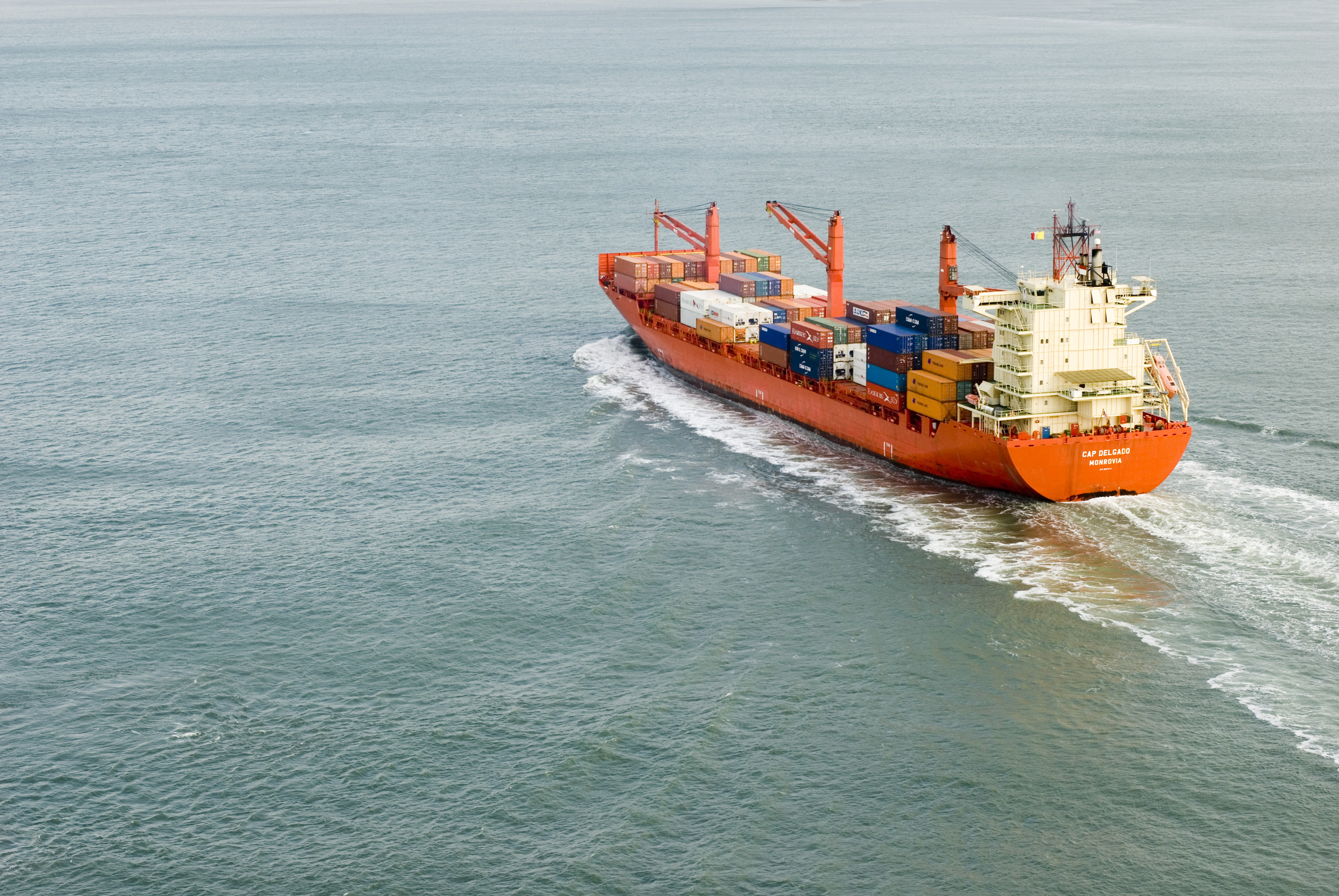 A large cargo ship full of shipping containers sailing into port